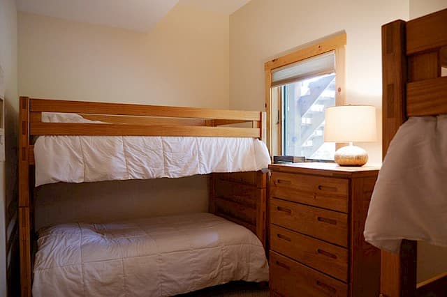 Family-friendly bedroom with a bunk bed setup (full on bottom, twin on top) and a matching wood dresser.