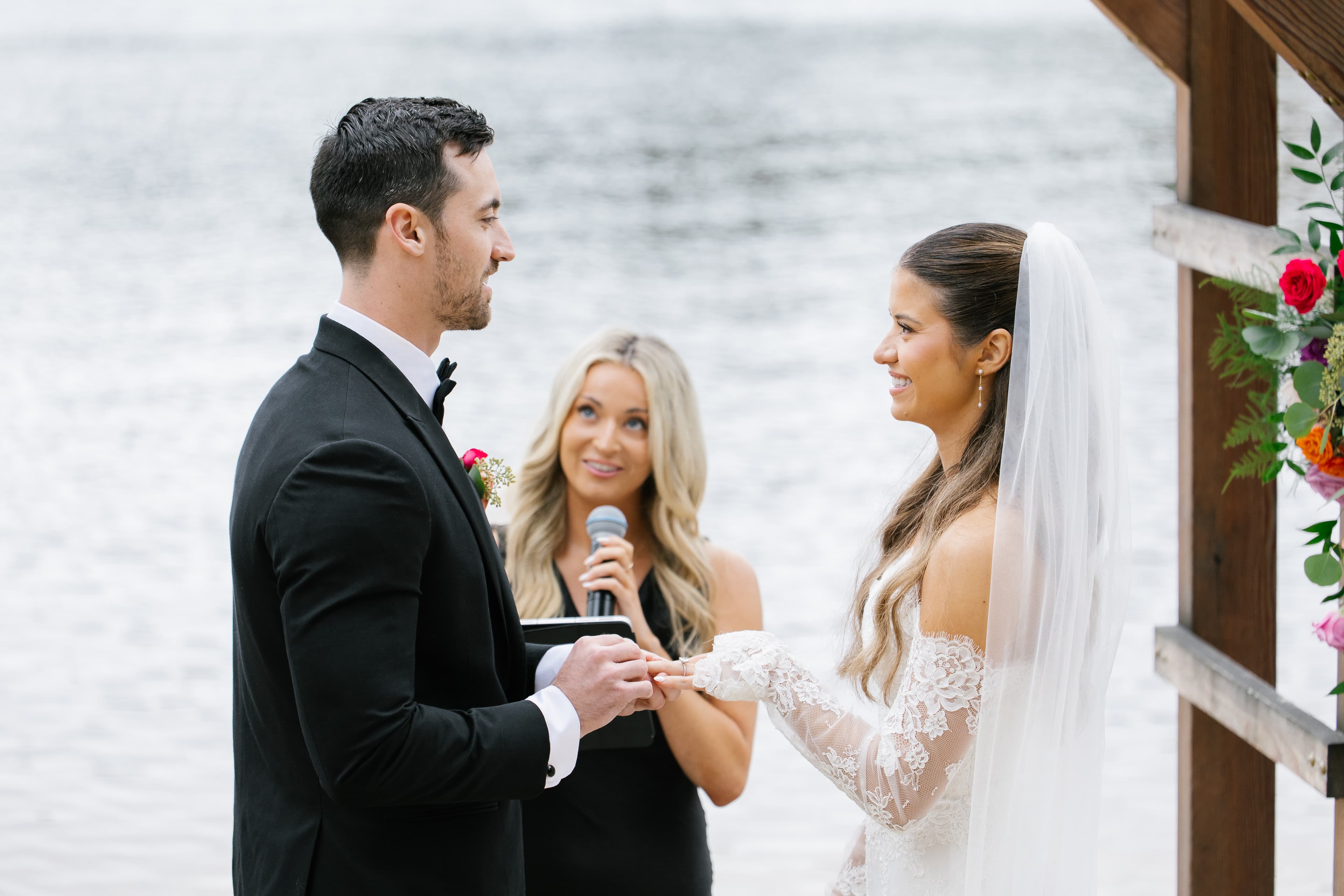 A couple exchanges vows during their wedding ceremony by a serene lakeside.