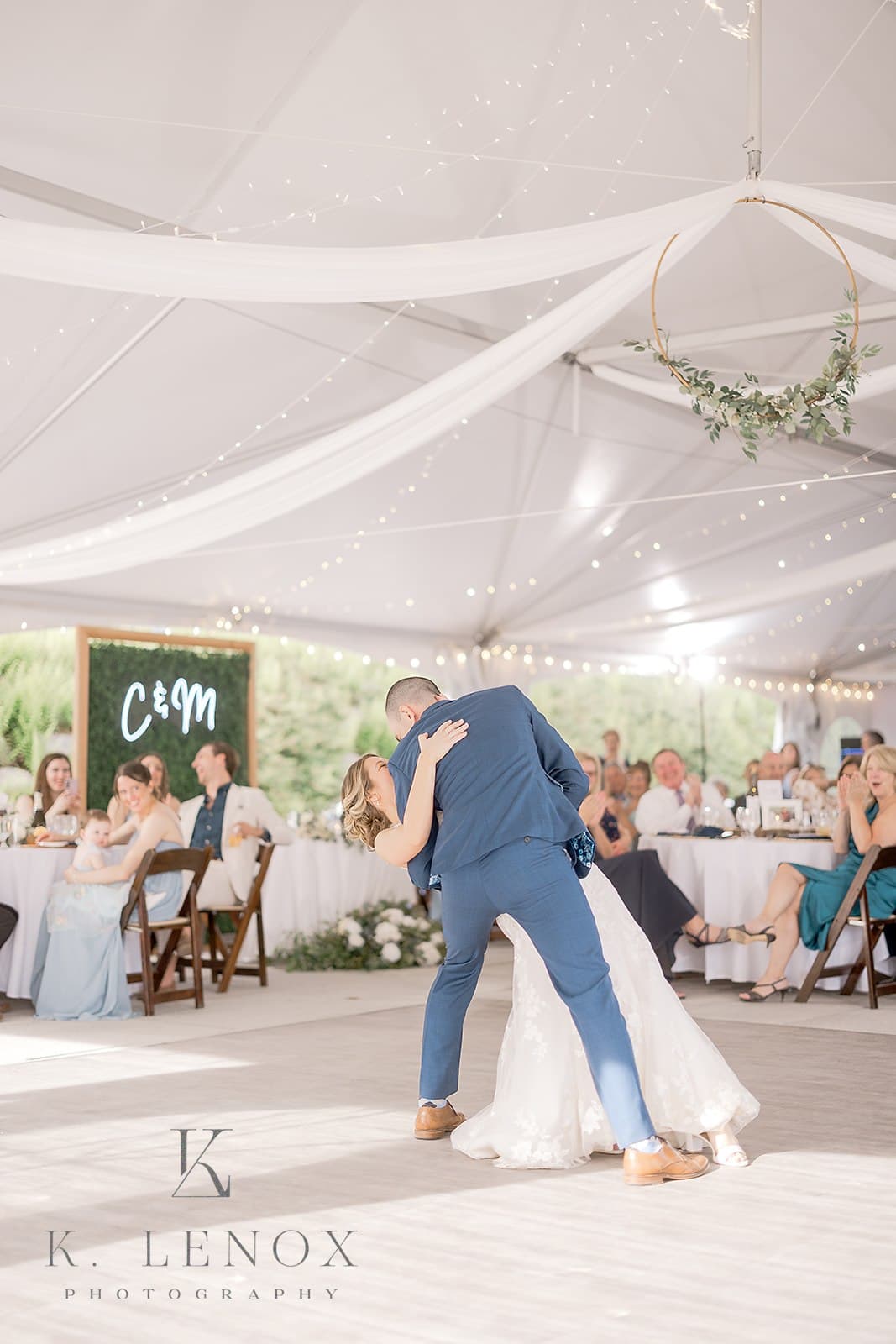 A couple shares a romantic dance under a decorated tent during their wedding reception.